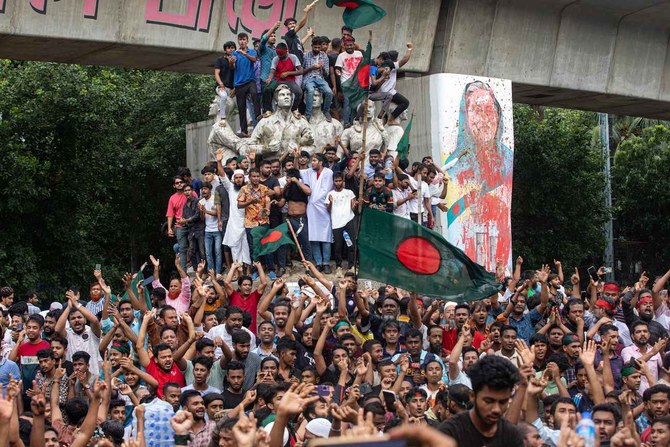 Protesters climb a public monument as they celebrate after getting the news of Prime Minister Sheikh Hasina's resignation, in Dhaka, Bangladesh on Aug. 5, 2024. (AP)